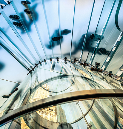 Escalera de vidrio que refleja las diferentes estructuras urbanísticas de la ciudad