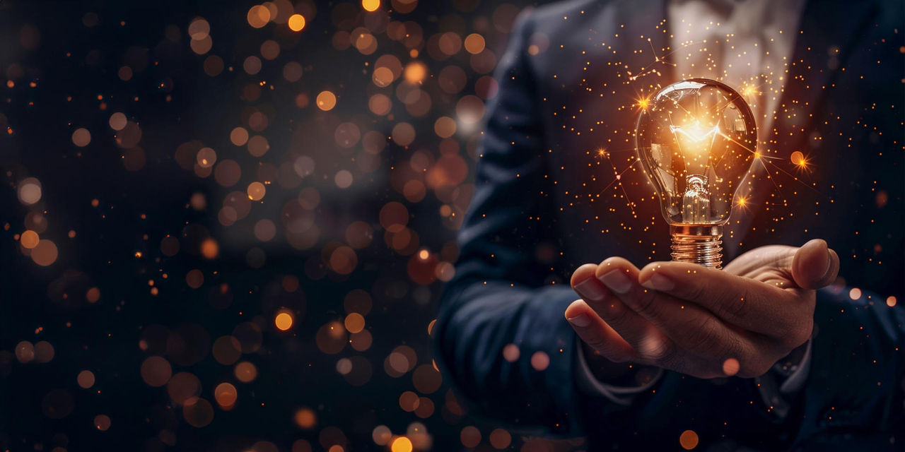 Primer pla d'una bombeta rodona encesa a les mans d'un home