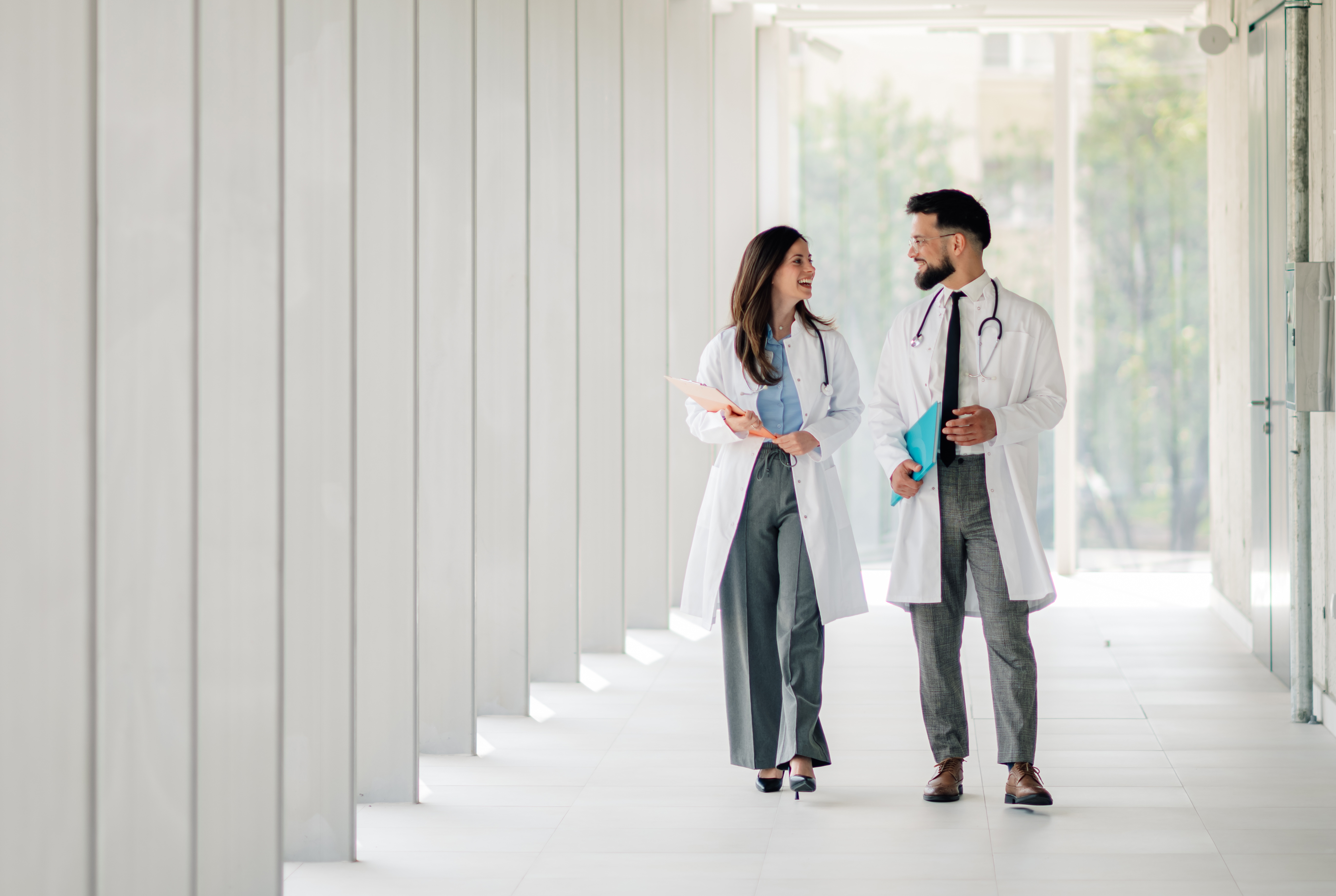 Two doctors walking and talking in hospital corridor