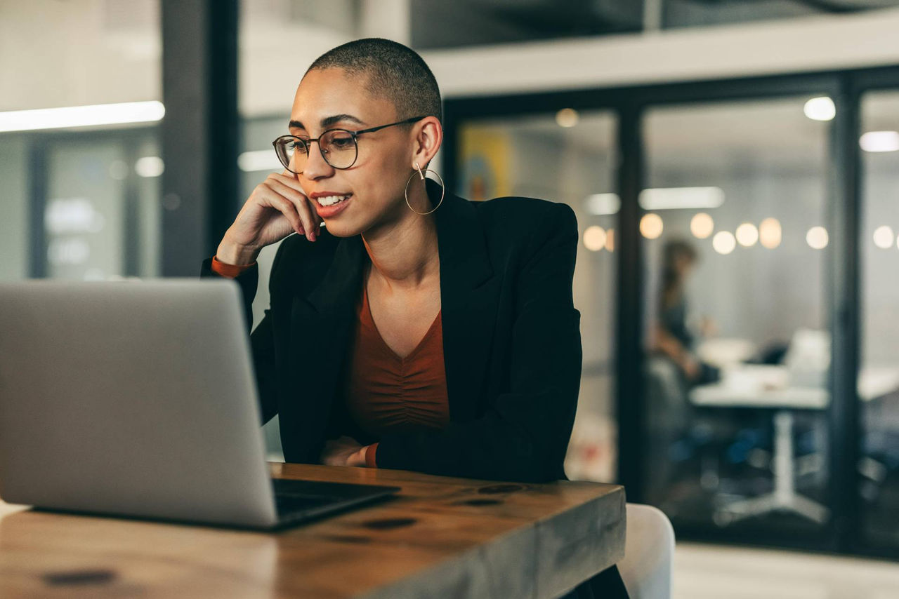 Chica joven consulta la oferta de estudios online de la UOC desde un ordenador.