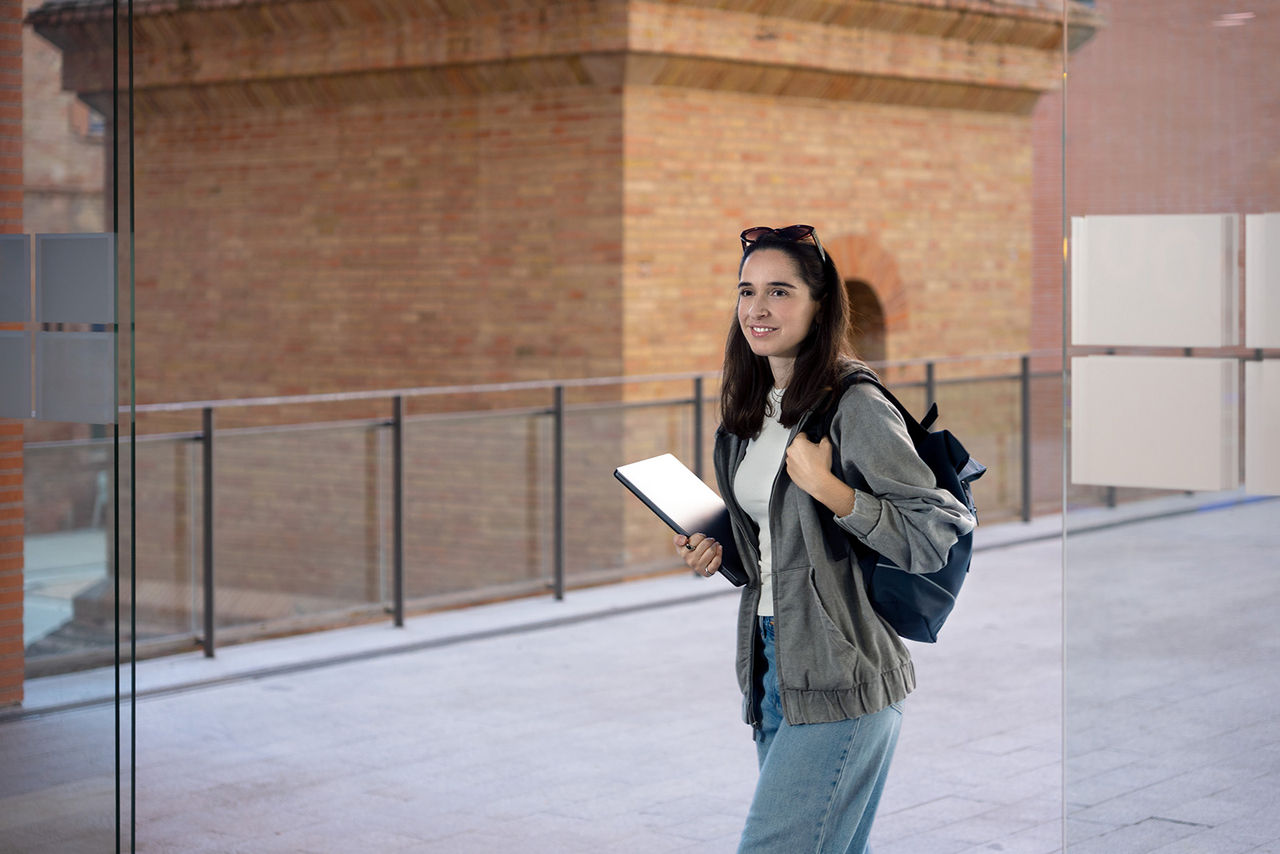 Chica jóven camina con una tablet