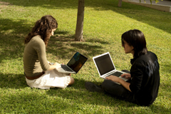 Dues noies amb port�tils a la gespa / Chris Reche (UOC)